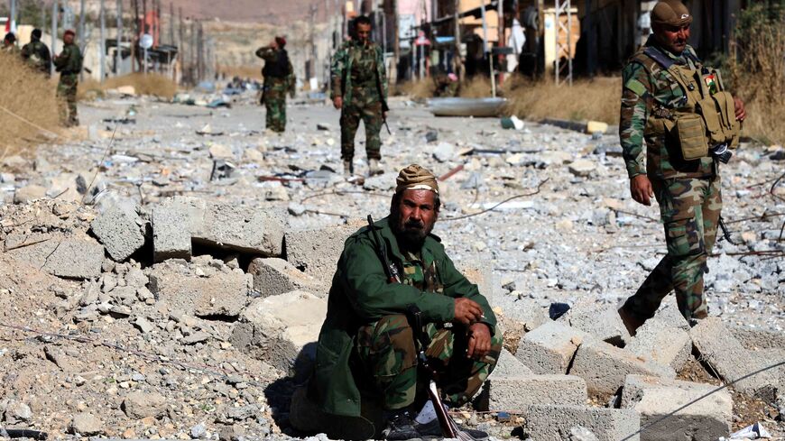 Iraqi autonomous Kurdish region's peshmerga forces and fighters from the Yazidi minority, a local Kurdish-speaking community targeted in a brutal campaign by the Islamic State (IS) group, enter the western Iraqi city of Sinjar, in the Nineveh Province, on Nov. 13, 2015.